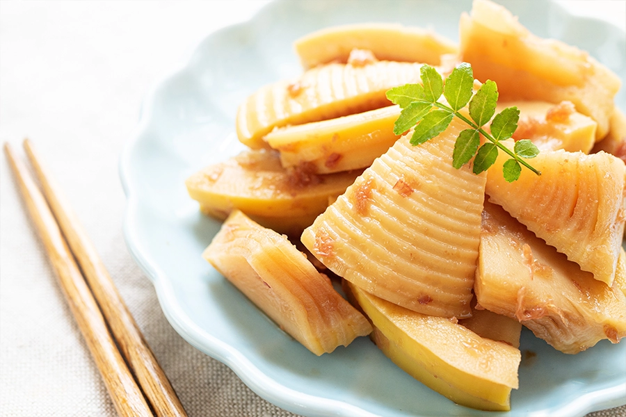 bamboo shoots on plate next to chopsticks 